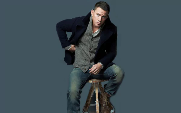 HD PC desktop wallpaper featuring American actor and celebrity Channing Tatum seated on a stool against a solid dark background.
