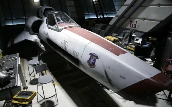 A high-definition desktop wallpaper featuring the iconic Colonial Viper spacecraft from the TV show Battlestar Galactica (2003) in a hangar.