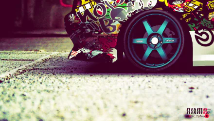 A close-up of a modified JDM vehicle featuring vibrant stickers and bold wheels, set against a textured surface. This HD image serves as an eye-catching desktop wallpaper.