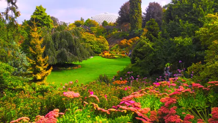 A vibrant scene from the Queen Elizabeth Gardens in Vancouver, showcasing lush greenery, blooming flowers, and diverse trees, all bathed in the beauty of spring.