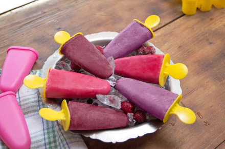 Raspberry and berry ice cream pops on crushed ice, yellow-handled molds arranged on a plate — summer food wallpaper with 5K Ultra HD detail and ice climbing textures.