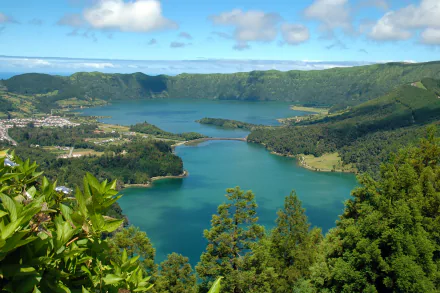 2K Quad HD desktop wallpaper, aerial photography of a turquoise crater lake in the Azores, Portugal, surrounded by lush green hills and a small village beneath a blue sky.