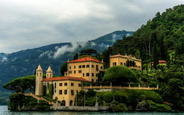 2K Quad HD PC desktop wallpaper: Italian coastal mountain scene with tree-covered slopes and a man-made villa house featuring classic architecture.