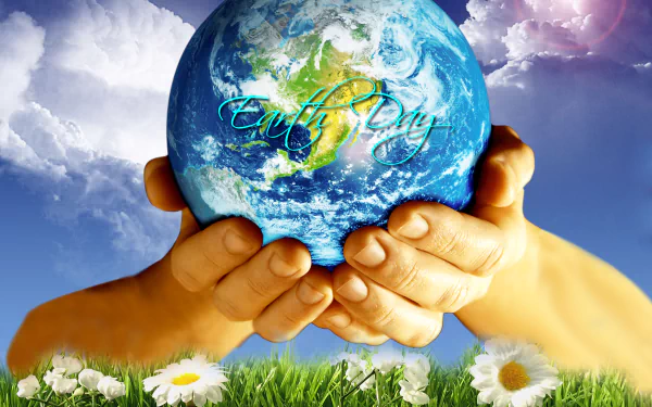 HD desktop wallpaper showing hands gently holding Earth with Earth Day text, set against a vibrant sky and grassy field with daisies, celebrating the holiday.