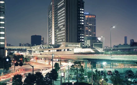 HD wallpaper featuring a vibrant night scene of Tokyo, Japan. Illuminated skyscrapers and busy streets showcase the bustling city life and impressive man-made structures.