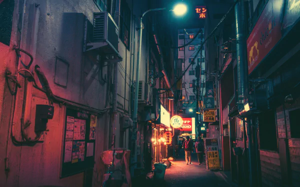 A neon-lit alleyway in a Japanese city at night, featuring building facades illuminated by colorful lights, captured in HD for a PC desktop wallpaper.