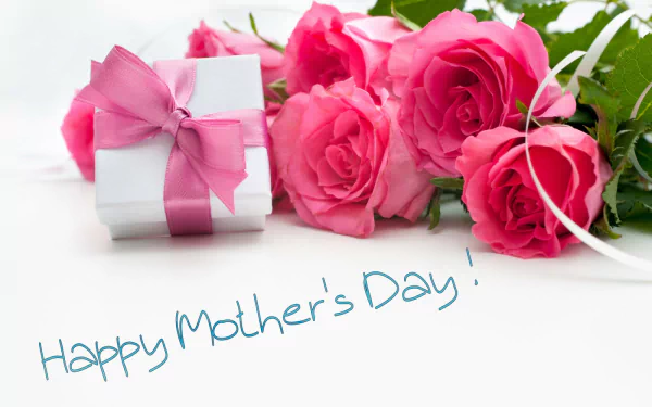 A beautifully arranged scene featuring a gift wrapped with a pink ribbon alongside vibrant pink roses, celebrating Mother's Day with the text Happy Mother's Day! in a cheerful font.