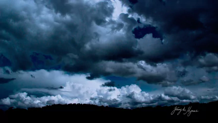 Dark blue storm clouds sweep across the sky above a silhouetted horizon — HD PC desktop wallpaper, nature background.
