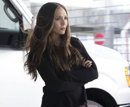 Elizabeth Olsen as Scarlet Witch in Captain America: Civil War stands with arms crossed in this HD desktop wallpaper and background.