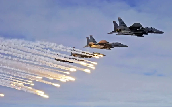 A striking HD desktop wallpaper featuring McDonnell Douglas F-15 Eagles in flight, releasing flares against a dramatic sky, showcasing military power and aerial precision.