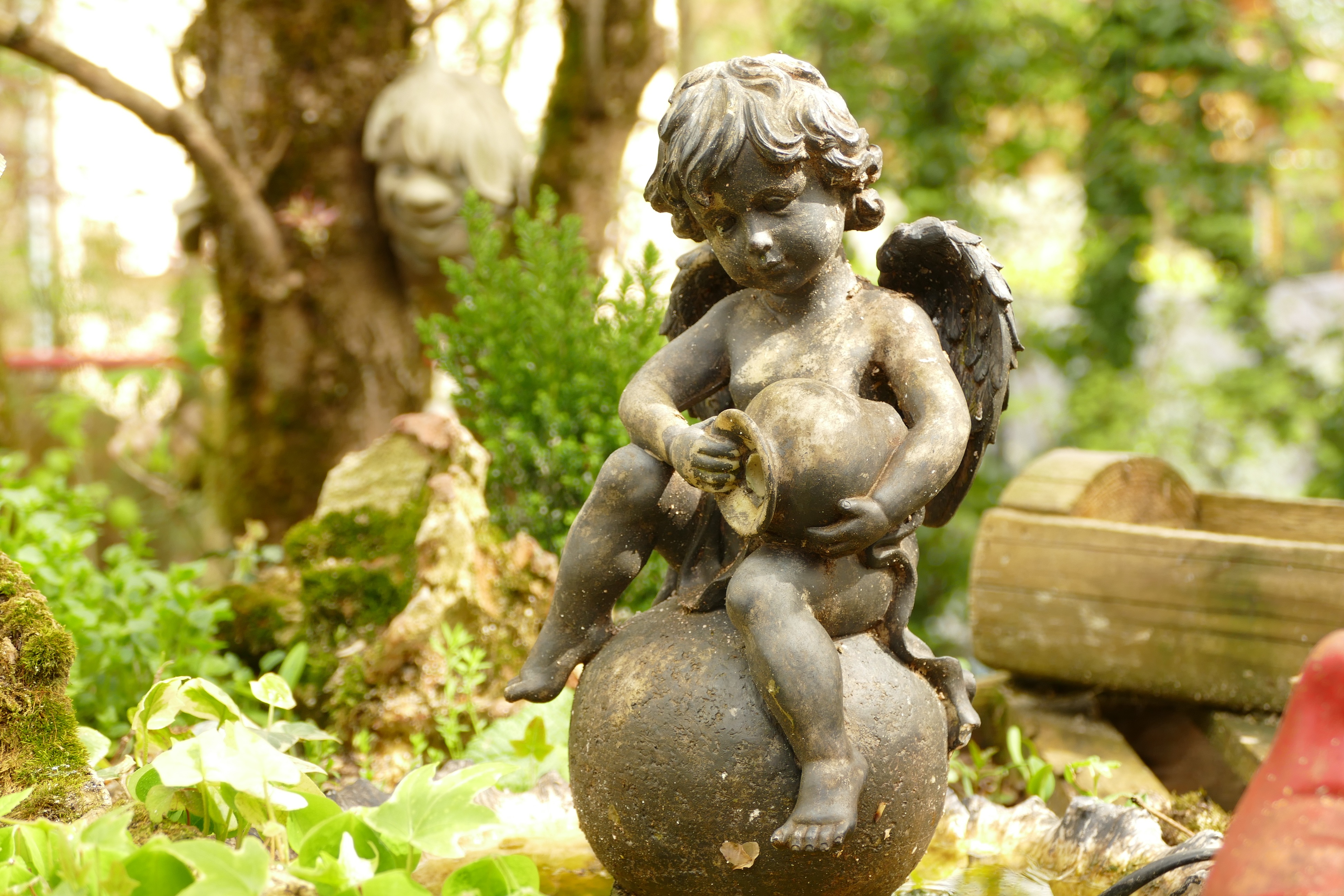 A cherub statue in a garden by jurasud