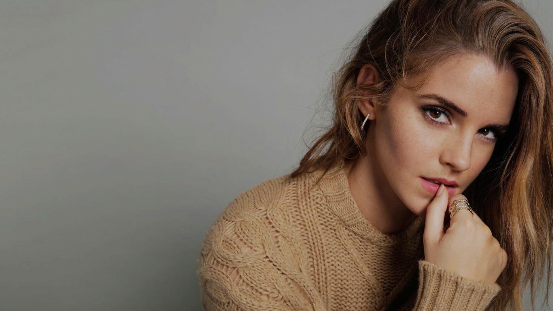 Emma Watson poses elegantly in a cozy sweater, offering a captivating look. This HD image serves as a striking wallpaper for any desktop background.