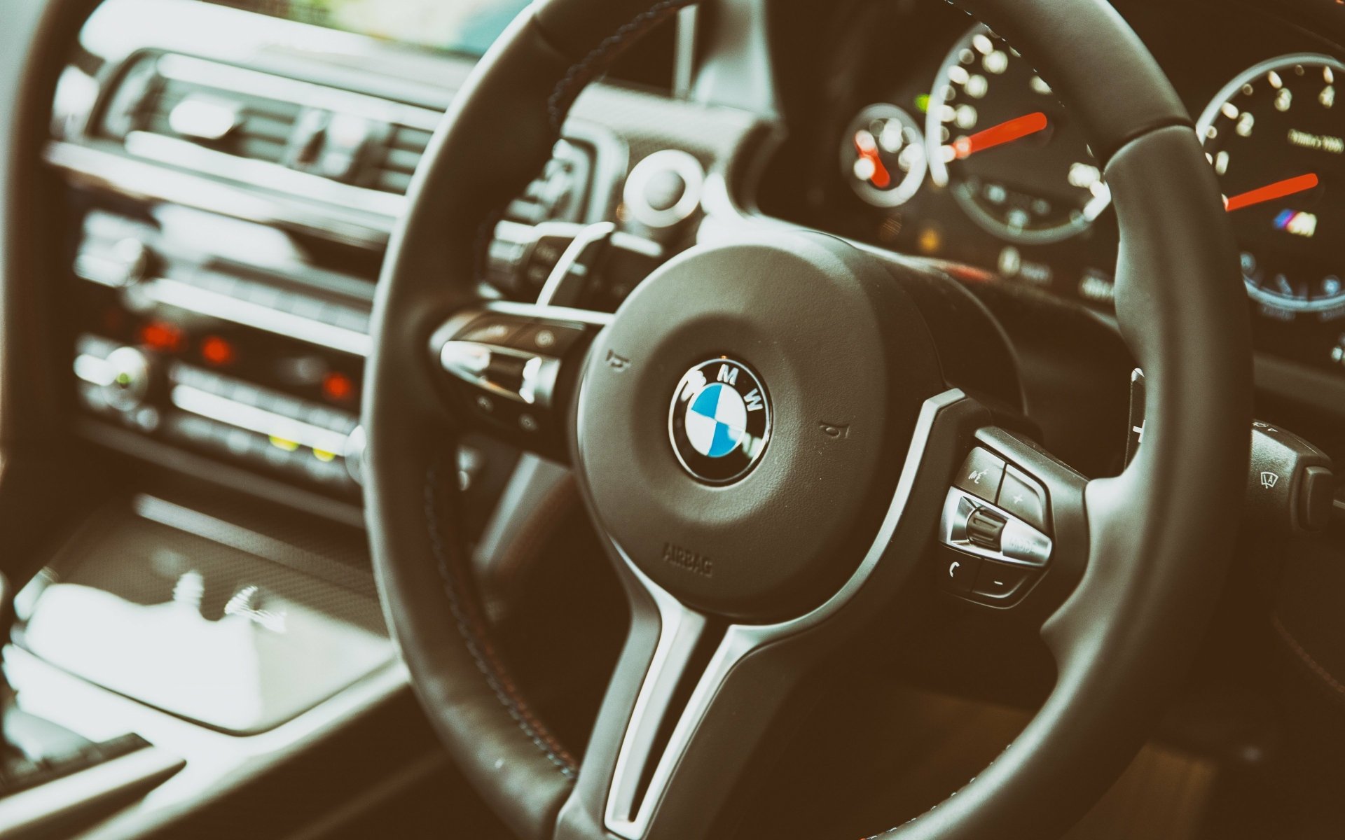 Close-up of a BMW steering wheel and dashboard interior, captured in stunning detail for a 4K Ultra HD PC desktop wallpaper and background.