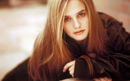 HD desktop wallpaper of blonde actress Alicia Silverstone with a soft-focus background, highlighting her intense gaze and natural beauty.