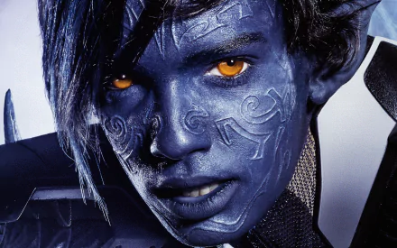 Close-up of Kodi Smit-McPhee as Nightcrawler from X-Men: Apocalypse, featuring his blue skin and striking orange eyes, set against a dynamic background.