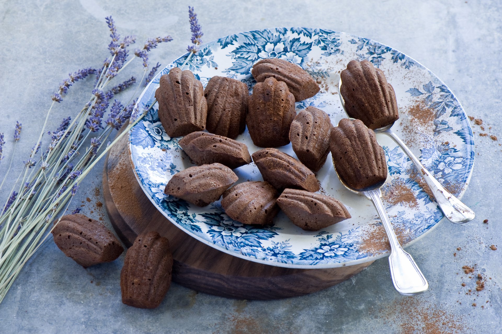 HD PC desktop wallpaper of chocolate Madeleines on a blue floral plate with lavender sprigs and two silver spoons — food-themed background.