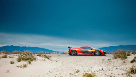 Orange McLaren P1 supercar parked on sandy desert terrain with clear blue sky and distant mountains, captured in HD for a striking desktop wallpaper.
