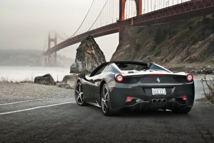 A sleek black Ferrari 458 Spider parked by the coast, with the iconic Golden Gate Bridge in the background. This stunning 4K Ultra HD image captures luxury and scenery.