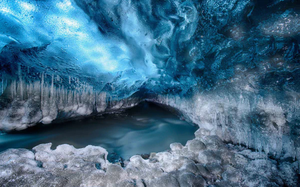 HD desktop wallpaper showcasing a stunning winter ice cave with crystalline icicles and frozen formations, capturing the serene beauty of nature in cold conditions.