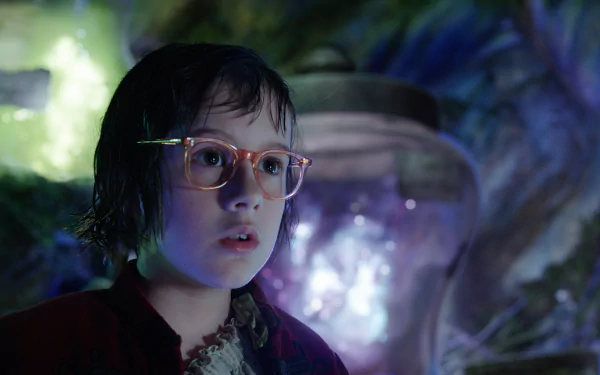 A young girl with glasses looks in awe, surrounded by a magical environment in a scene from the movie The BFG (2016). This HD image makes an enchanting desktop wallpaper.
