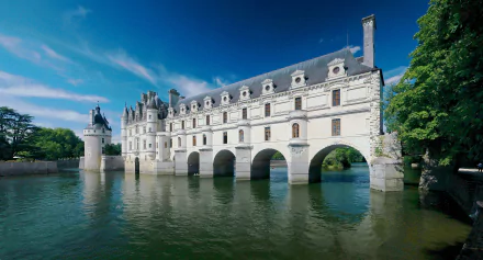 4K Ultra HD image of Château de Chenonceau, a man-made historic castle in France, gracefully spanning the river under a clear blue sky.