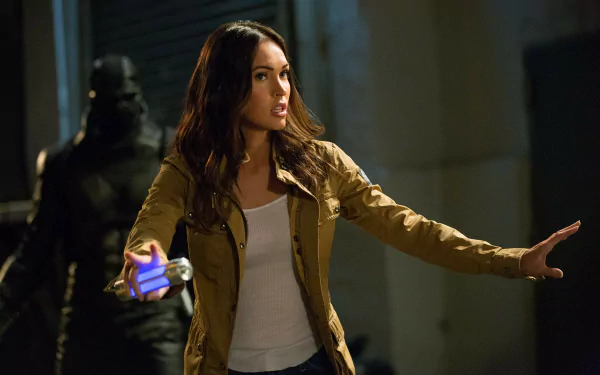 Megan Fox as April O'Neil in Teenage Mutant Ninja Turtles: Out of the Shadows, showcasing her character in an intense moment with a flashlight. HD desktop wallpaper.