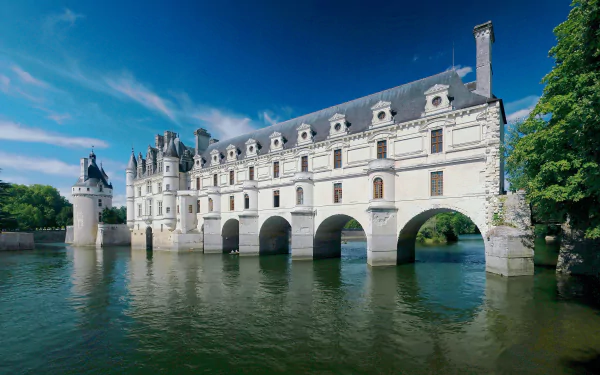 4K Ultra HD image of Château de Chenonceau, a man-made historic castle in France, gracefully spanning the river under a clear blue sky.