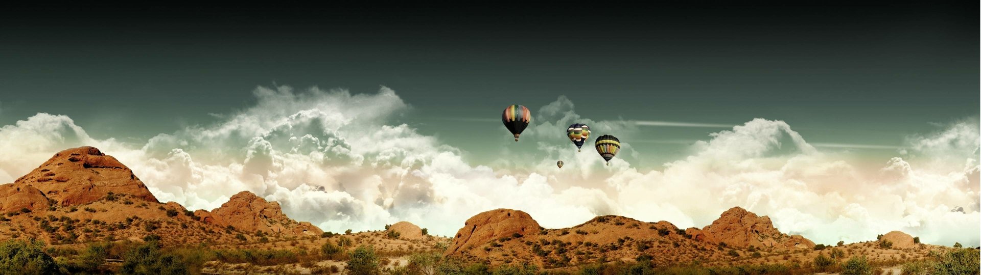 A stunning HD wallpaper featuring vibrant hot air balloons soaring in a clear sky above a rugged desert landscape, creating a sense of adventure and tranquility.