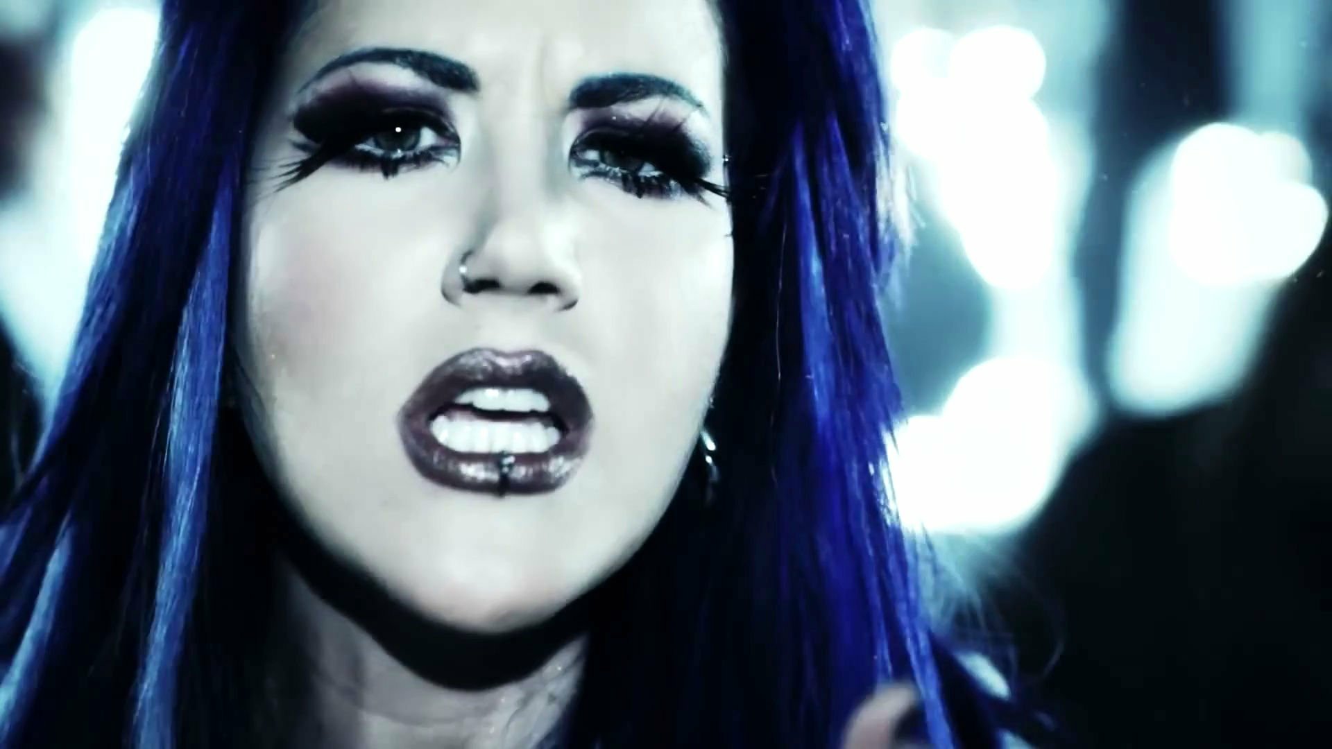 HD PC desktop wallpaper featuring a close-up of a woman with blue hair and dramatic makeup, linked to the music band Arch Enemy.