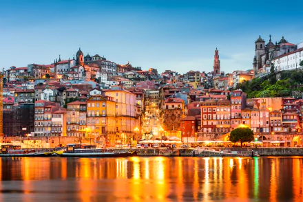 Vibrant 4K Ultra HD view of Porto, Portugal showcasing colorful houses and historic architecture illuminated against the evening sky along the waterfront.