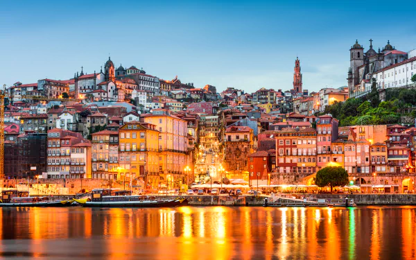 Vibrant 4K Ultra HD view of Porto, Portugal showcasing colorful houses and historic architecture illuminated against the evening sky along the waterfront.