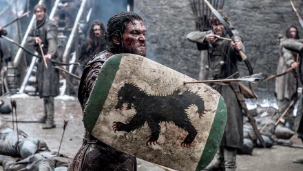Jon Snow, portrayed by Kit Harington, stands fiercely with a shield featuring a black wolf, ready for battle in this intense scene from *Game of Thrones*, presented as a high-definition wallpaper.