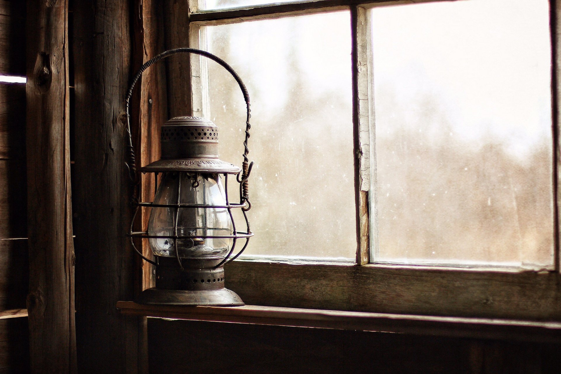 An old man-made lantern hanging by a weathered window, captured in a high-definition desktop wallpaper and background.