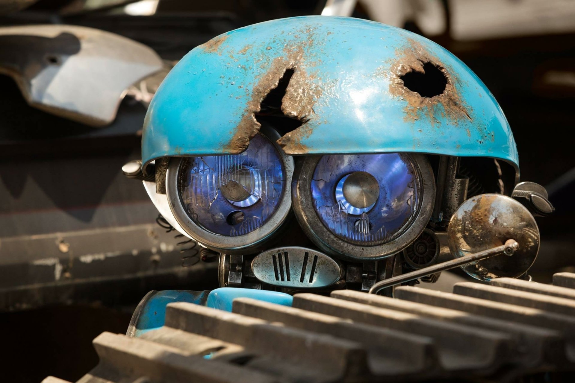 A close-up of a weathered blue robot with a cracked helmet and expressive eyes, serving as a striking HD wallpaper inspired by Transformers: The Last Knight.