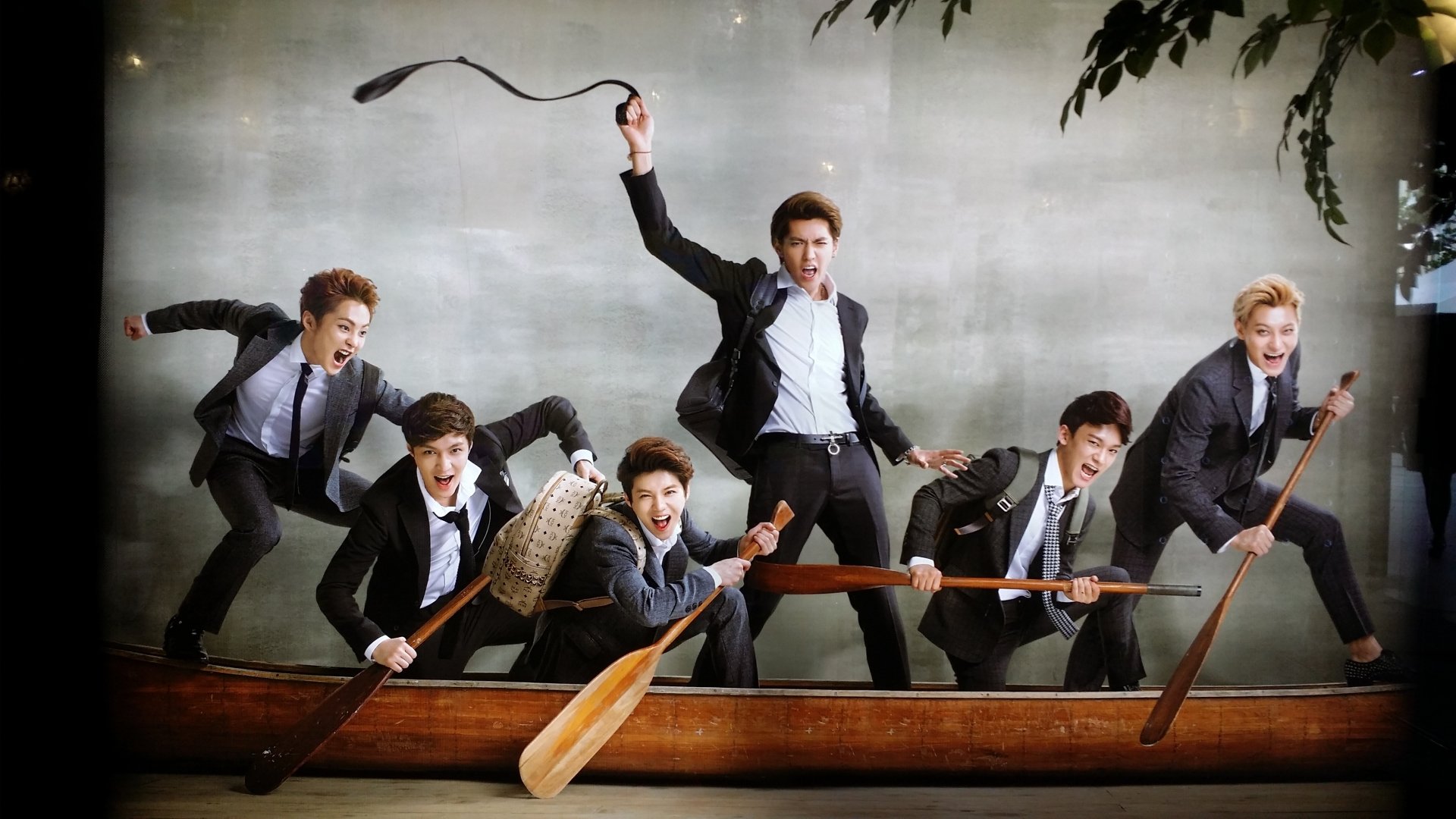 HD wallpaper featuring members of Exo in suits playfully posing in a boat for a dynamic desktop background.