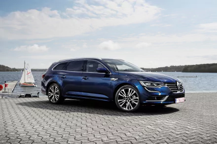 A sleek blue Renault Talisman vehicle parked on a waterfront promenade under a partly cloudy sky, captured in 4K Ultra HD quality for PC desktop wallpaper.