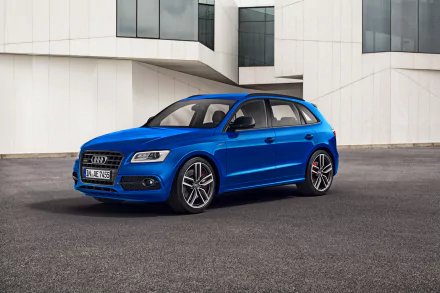 A blue Audi Q5 SUV parked on an urban street in front of a modern white building, shown in crisp 4K Ultra HD quality as a desktop wallpaper.