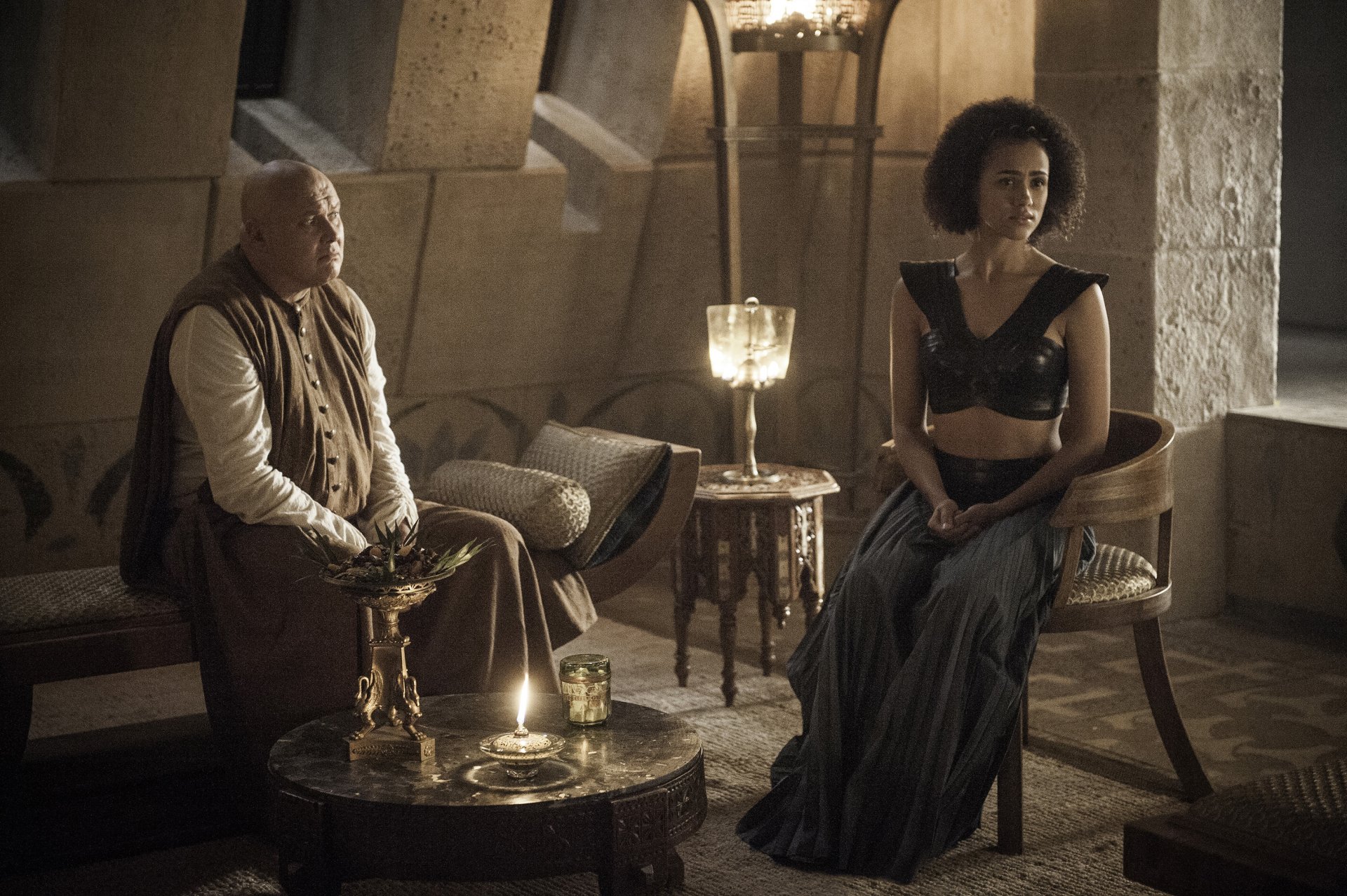 HD wallpaper featuring Lord Varys (Conleth Hill) and Missandei (Nathalie Emmanuel) from the TV show Game of Thrones in a dimly lit, medieval setting.