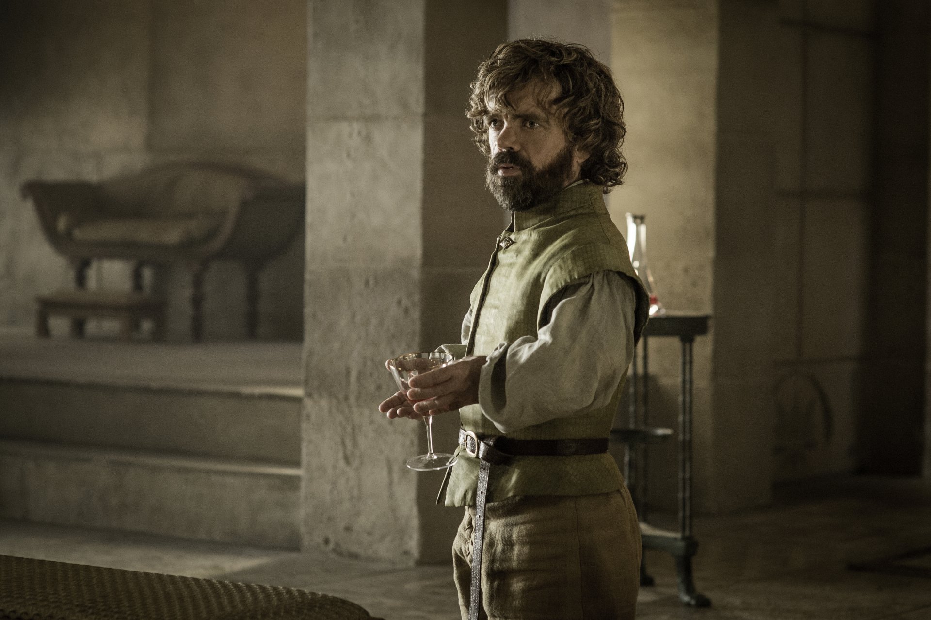 Short bearded man in a green medieval doublet holding a glass in a stone hall — moody 4K Game of Thrones TV series desktop wallpaper.