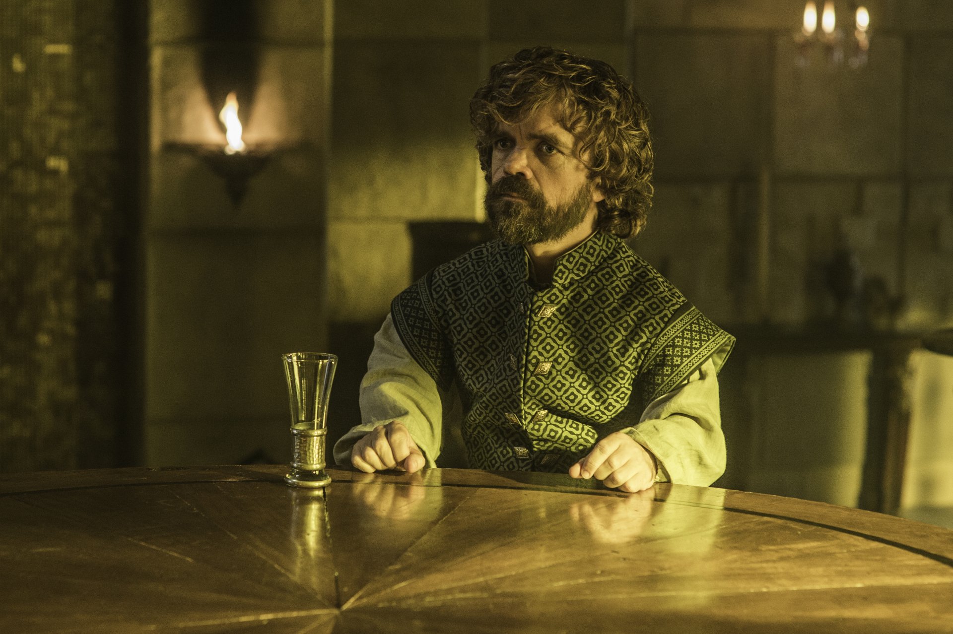 Bearded man in ornate medieval tunic seated at a wooden table with a goblet in a dim, torchlit hall — 4K Ultra HD TV show desktop wallpaper.