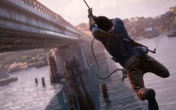Nathan Drake swings across a river in a striking scene from Uncharted 4: A Thief's End, showcasing adventure and action in this high-definition desktop wallpaper.