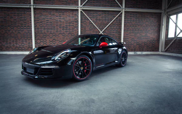 Black Porsche 911 Carrera parked in an industrial-style garage, showcased in a 4K Ultra HD PC desktop wallpaper and background.
