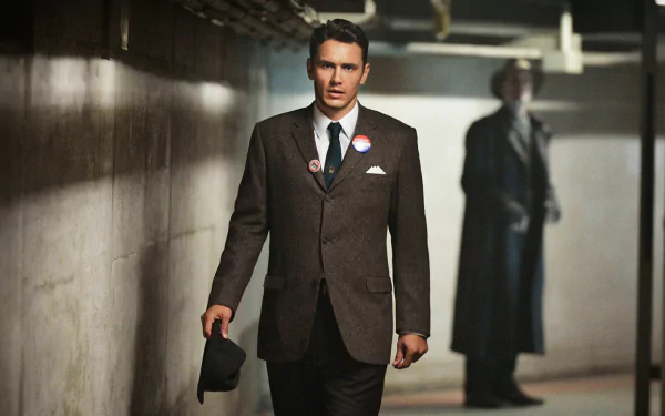 HD PC desktop wallpaper: moody scene from TV show 11.22.63 — a man in a 1960s suit walks through a dim corridor holding a hat, with a shadowy figure standing in the background.