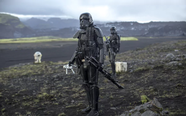 A Stormtrooper from the Death Squad in Rogue One: A Star Wars Story stands on a rugged landscape, with a fellow trooper in the background, creating an intense cinematic atmosphere.
