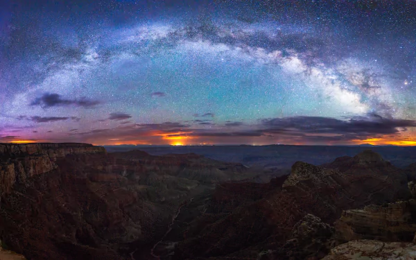 A breathtaking view of the Milky Way arching across a starry night sky over the Grand Canyon in Arizona, showcasing the beauty of nature in vibrant colors and intricate landscapes.
