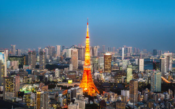 A vibrant 4K Ultra HD cityscape of Tokyo, showcasing the illuminated Tokyo Tower amidst skyscrapers and buildings under a clear evening sky.