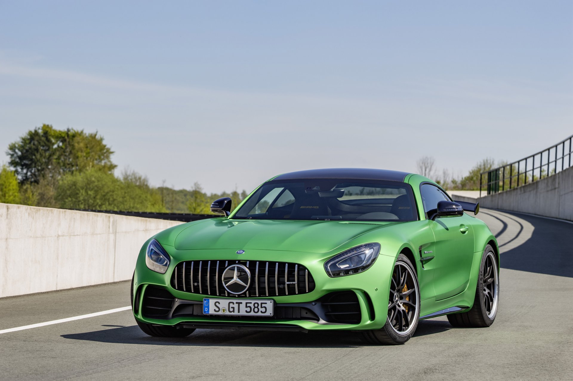 4K Ultra HD PC desktop wallpaper of a green Mercedes-AMG GT supercar on a curved road, showcasing Mercedes-Benz's aggressive grille and sleek, sporty profile.