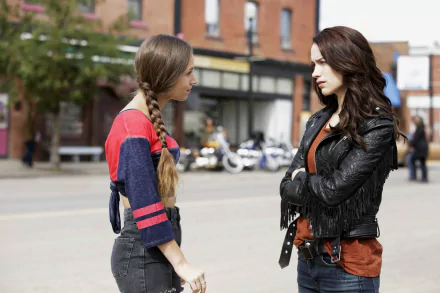 HD desktop wallpaper featuring Dominique Provost-Chalkley as Waverly Earp and Melanie Scrofano from the TV show Wynonna Earp in a street confrontation scene.