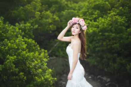 A brunette bride wearing a wedding dress and a floral wreath poses gracefully against a lush green background, captured in stunning HD detail.