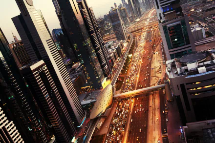 HD PC desktop wallpaper: aerial dusk view of Dubai's man-made skyline and illuminated Sheikh Zayed Road, skyscrapers flanking a busy multi-lane highway.